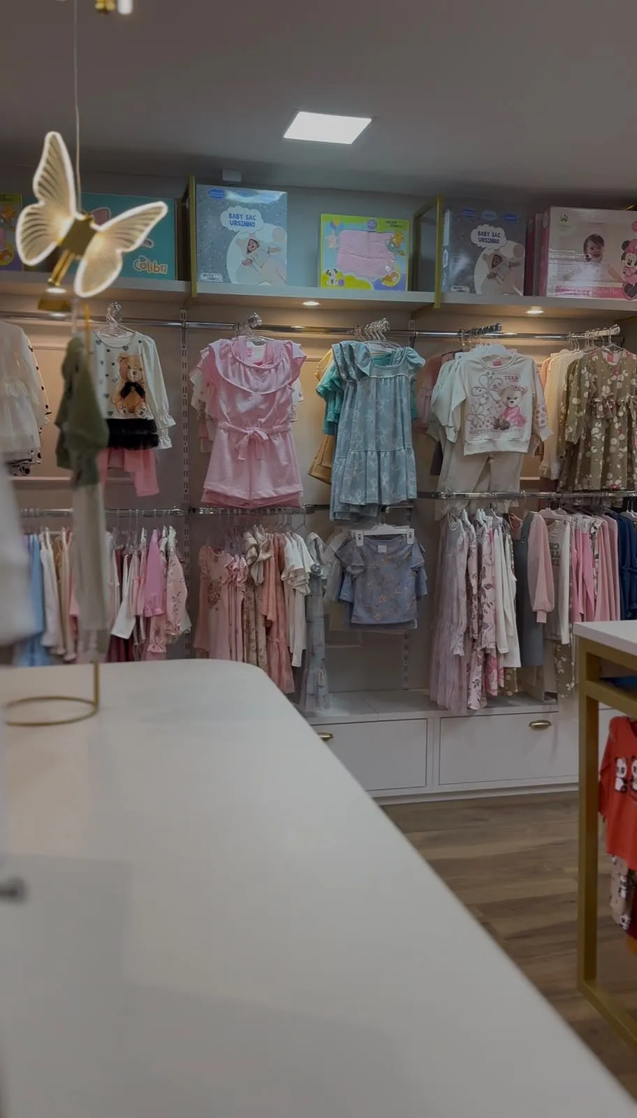 Parede de roupas de menina na loja do Bacacheri