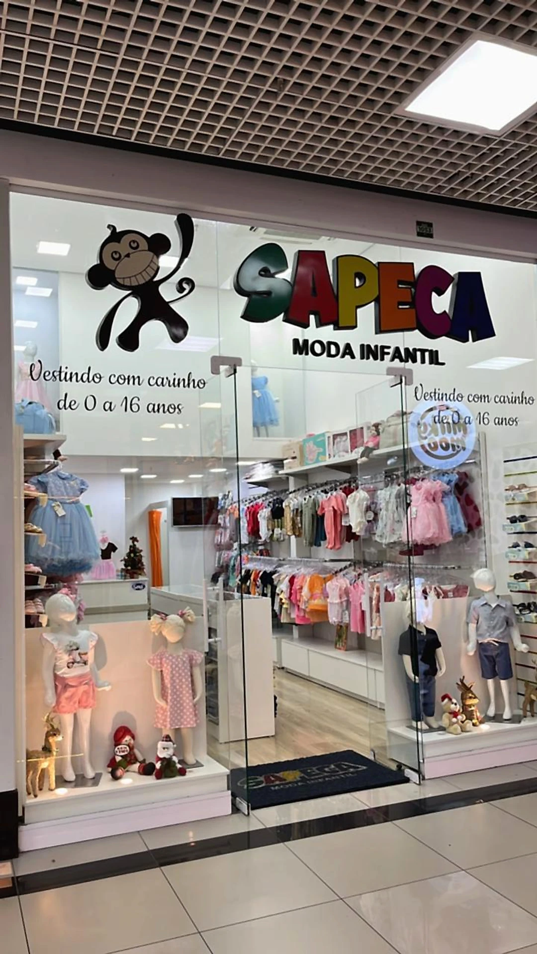 Vitrine da loja Sapeca no Colombo Park Shopping, com o macaquinho e o letreiro colorido